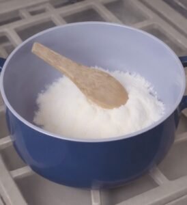 Préparation du foufou africain : la farine de manioc dans une marmite bleue avant d'ajouter l'eau.