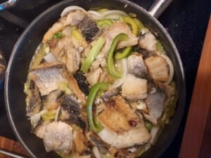 Phase finale de la cuisson du Makayabu aux poivrons, avec tous les légumes et le poisson qui mijotent ensemble.