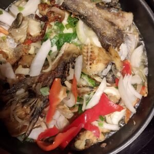 Le makayabu mijotant dans la poêle après l'ajout de poivrons rouges et de ciboule pour plus de saveur.